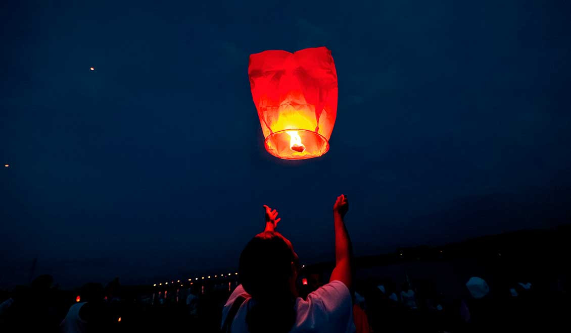 Une personne lève une lanterne céleste