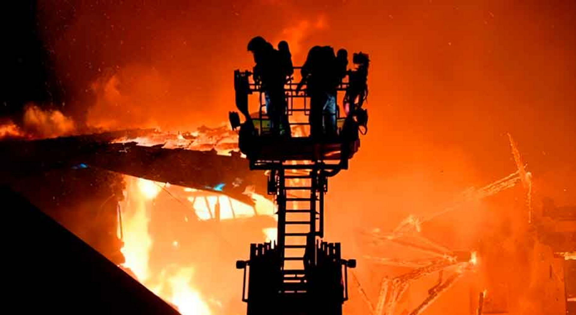 Mehrere Feuerwehrleute bekämpfen das Feuer von der Drehleiter aus