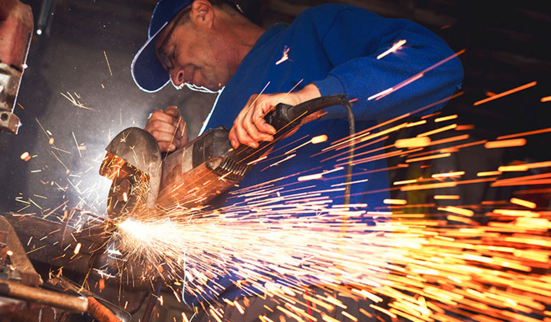 Ein Mann arbeitet mit einem Winkelschleifer