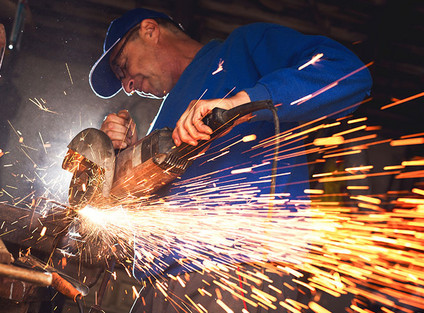 Ein Mann arbeitet mit einem Winkelschleifer