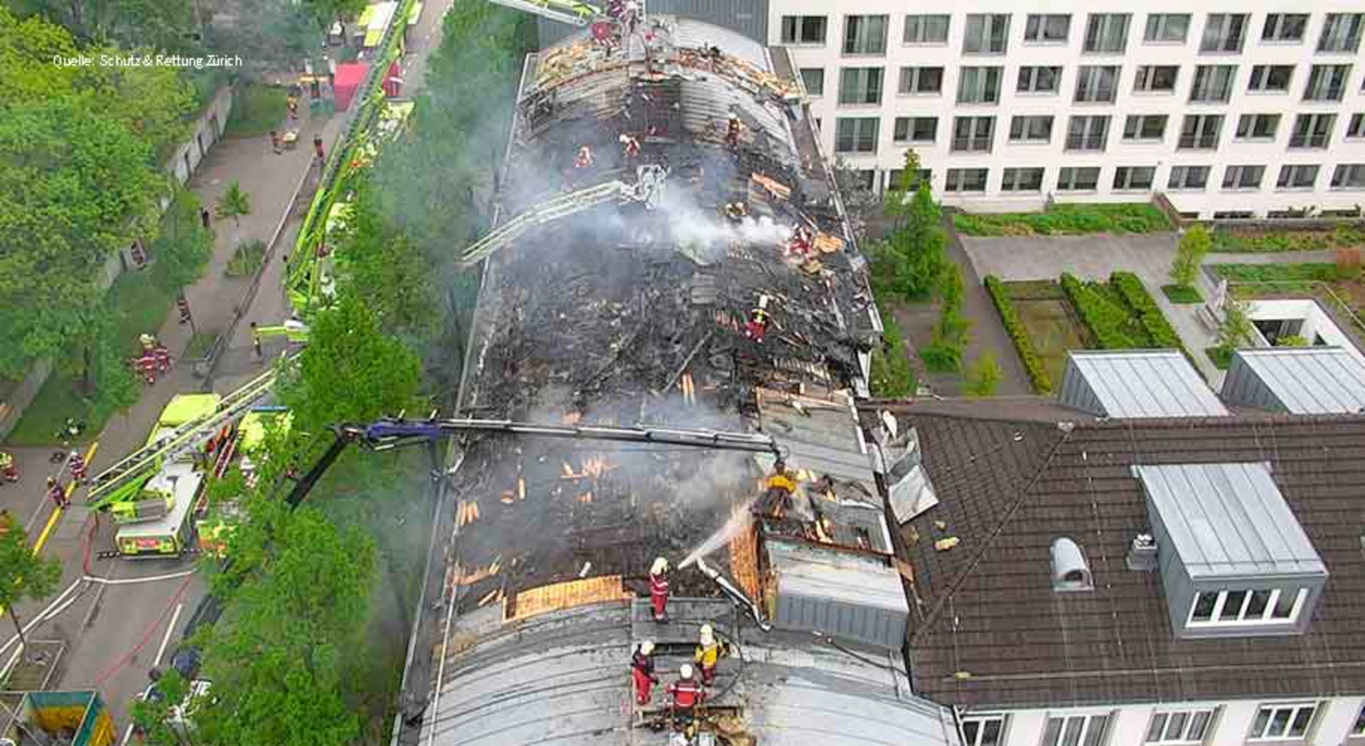 Mehrere Feuerwehrleute löschen einen Dachstockbrand.
