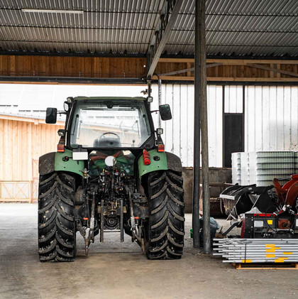 Un tracteur est garé dans un local des stationnement séparé. 