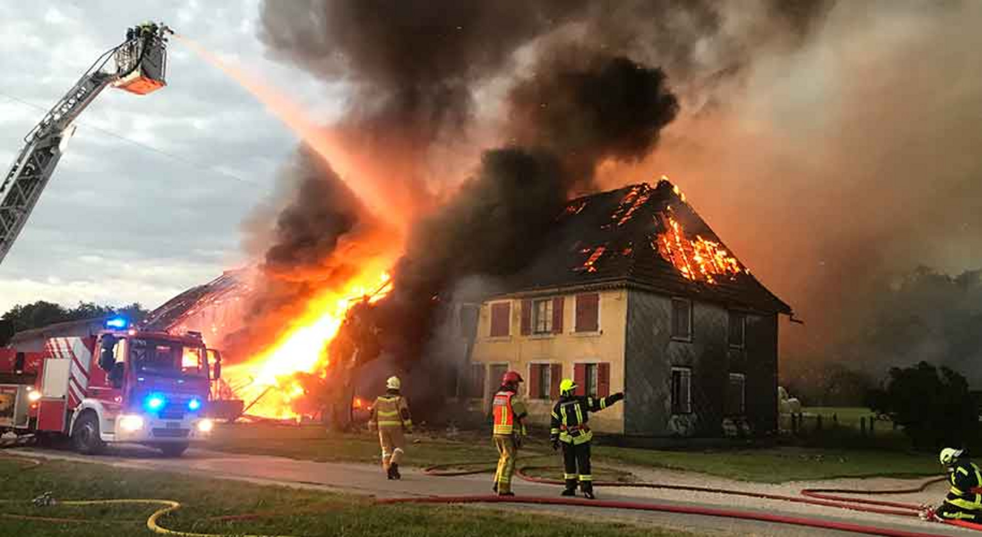 Die Feuerwehr bekämpft einen Hausbrand von der Drehleiter aus