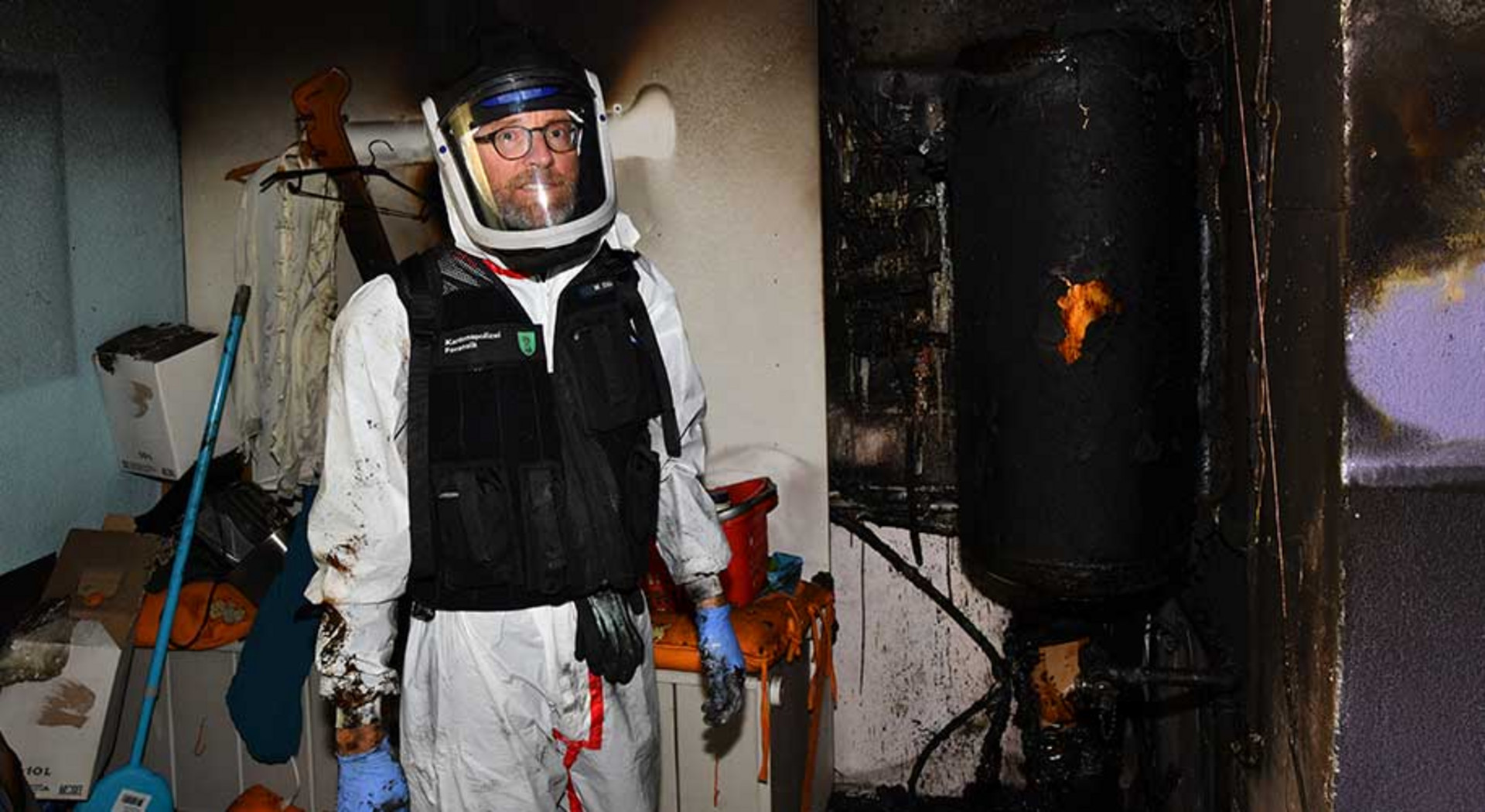 Ein Brandermittler in einem ausgebrannten Zimmer.