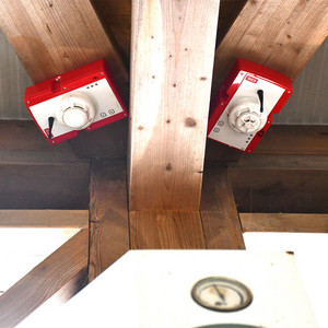 Ein Rauchmelder und ein Wärmemelder sind an der Holzdecke montiert. 