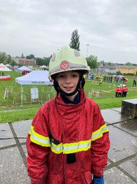 Ein Knabe in einer roten Feuerwehruniform