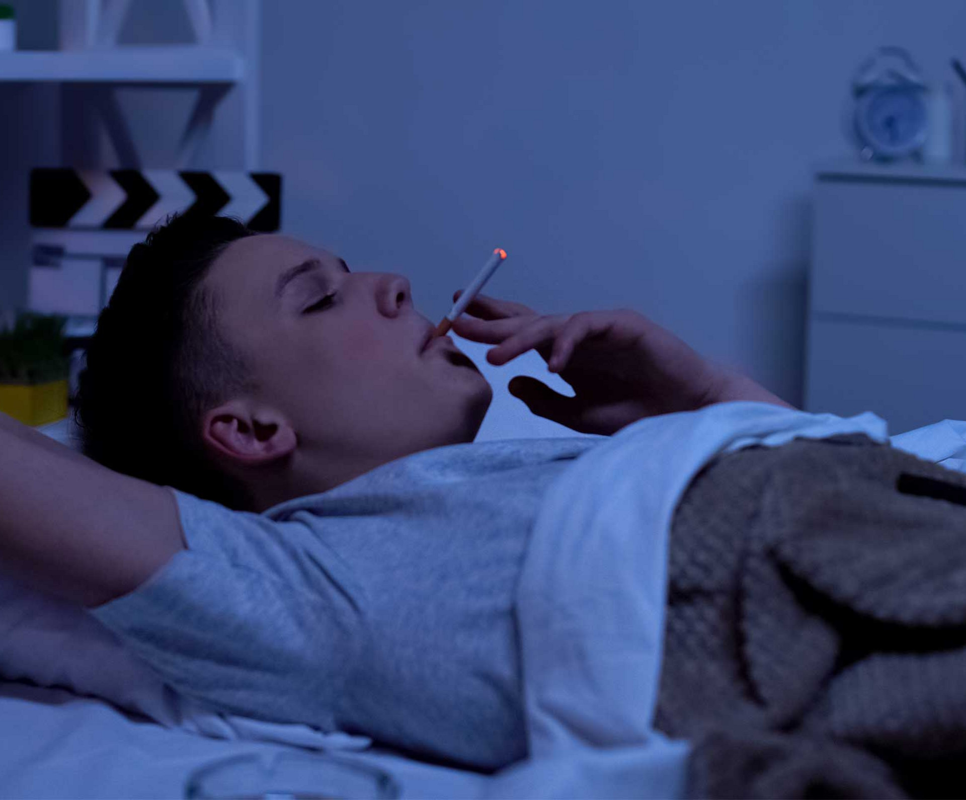 Ein Mann raucht im Bett