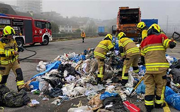 Feuerwehrmänner untersuchen einen Brand im Abfall. 