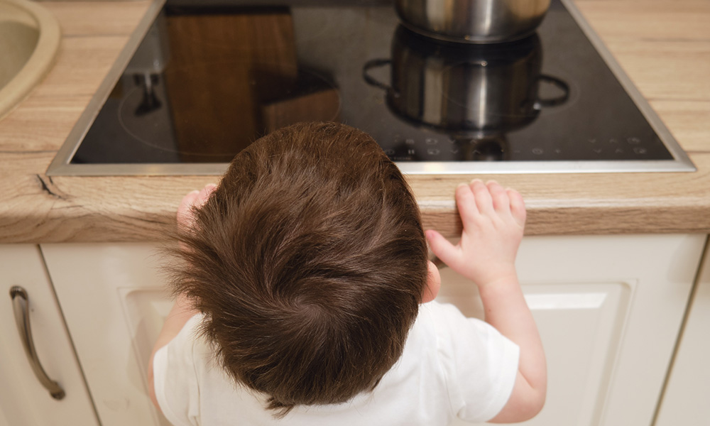 Un petit enfant regarde la plaque de cuisson