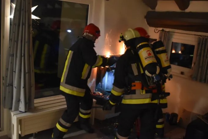 Drei Feuerwehrleute löschen den Brand beim Cheminée