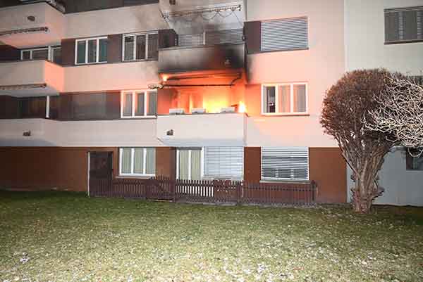 Flammen dringen aus einer Wohnung in einem Mehrfamilienhaus