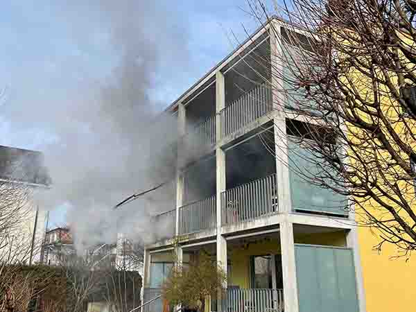 Von einem Balkon einer Wohnung eines Mehrfamilienhauses steigt Rauch auf.