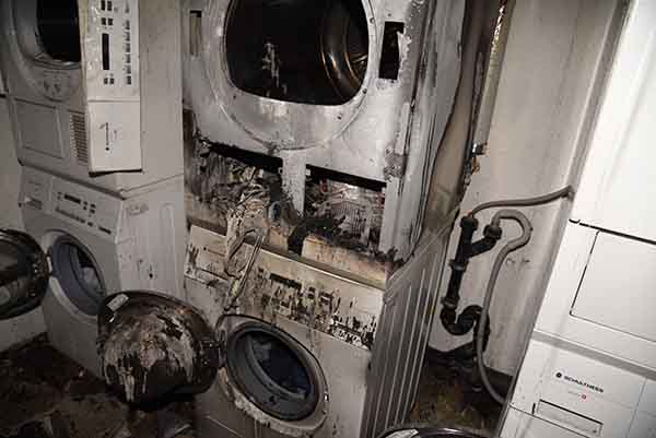 Ein verbrannter Tumbler steht auf einer verbrannten Waschmaschine.